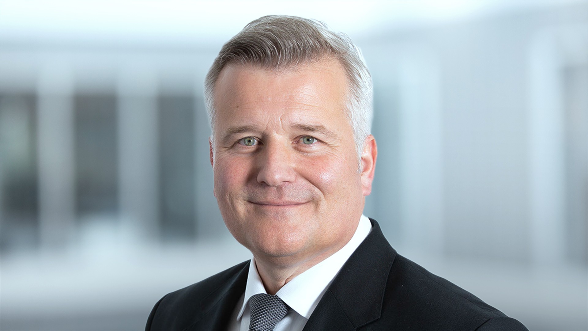 Business professional smiling in a corporate setting.